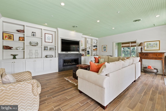 living room with built in features and hardwood / wood-style floors