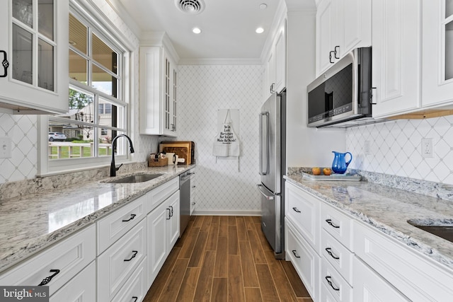 kitchen featuring crown molding, appliances with stainless steel finishes, tasteful backsplash, and white cabinetry