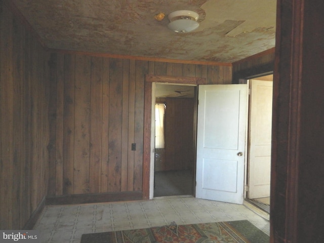 unfurnished room featuring wooden walls