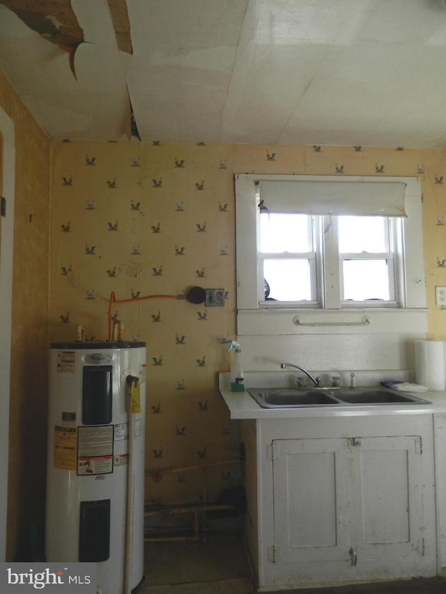 kitchen with white cabinets, sink, and water heater