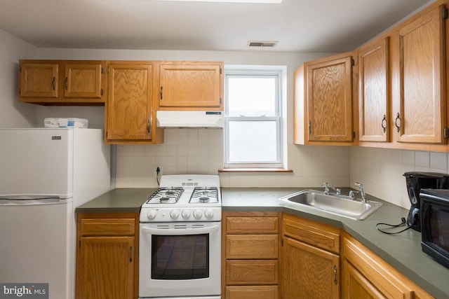 kitchen with white appliances, sink, and tasteful backsplash