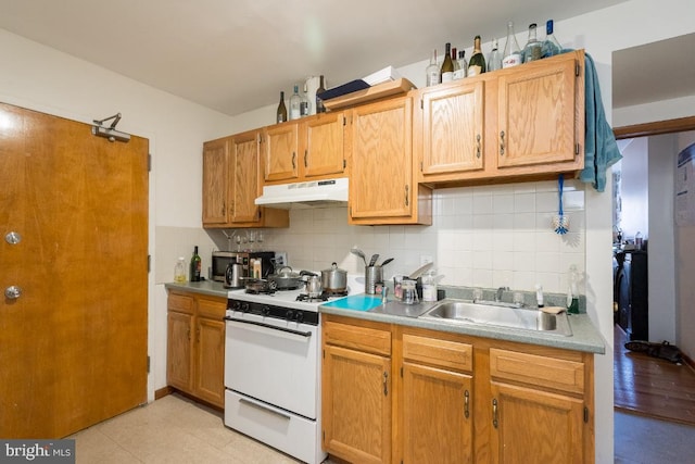 kitchen with light hardwood / wood-style flooring, white range, sink, and tasteful backsplash