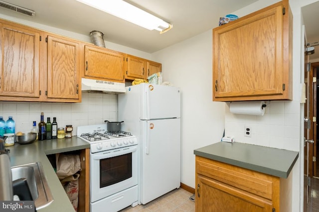 kitchen with sink, white appliances, backsplash, and light tile floors