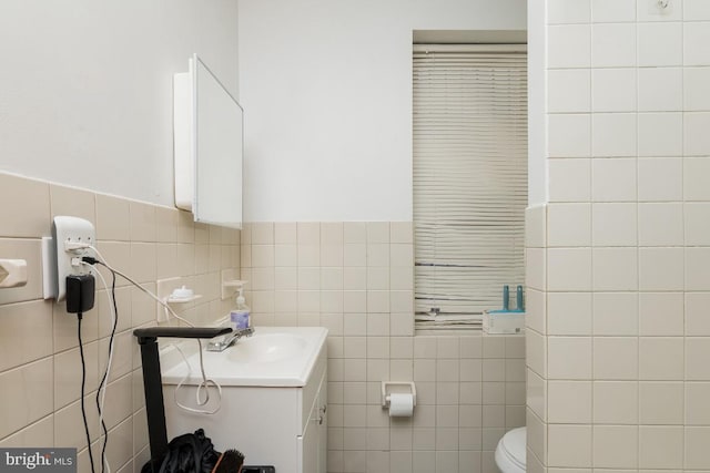 bathroom featuring backsplash, oversized vanity, toilet, and tile walls