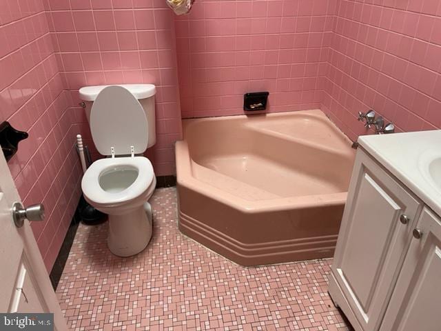 full bathroom with tile walls, toilet, tile floors, shower / bathtub combination, and vanity