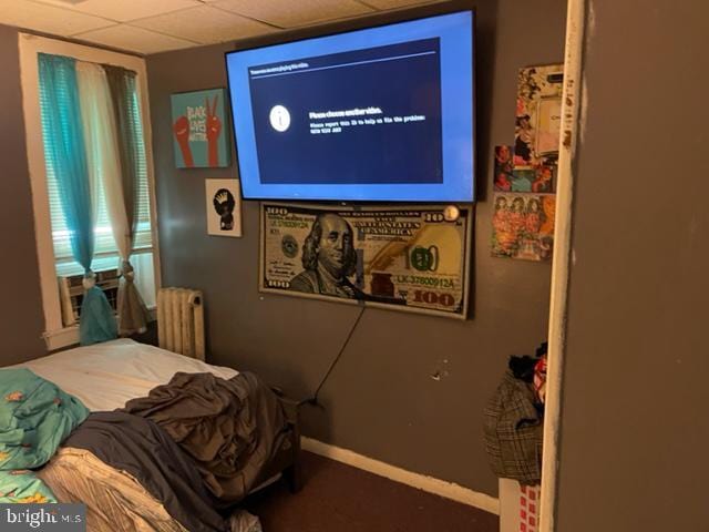 bedroom featuring a paneled ceiling and radiator