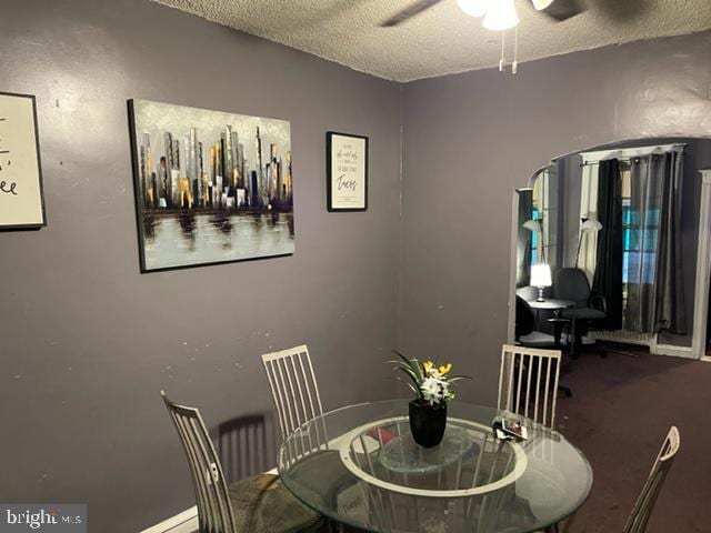 dining space featuring ceiling fan and a textured ceiling