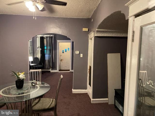 carpeted dining space featuring a textured ceiling and ceiling fan