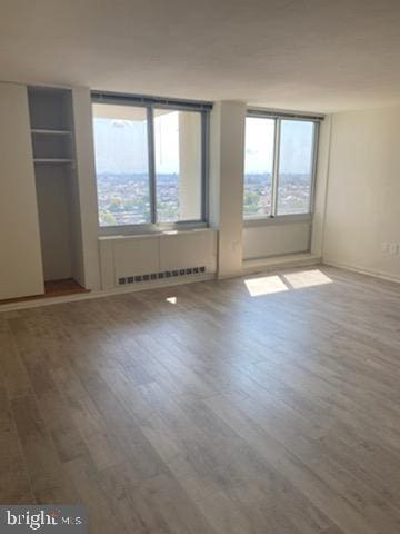 empty room featuring radiator and wood-type flooring