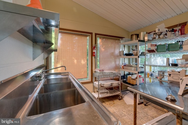 interior space with lofted ceiling, wood ceiling, light tile floors, and stainless steel counters