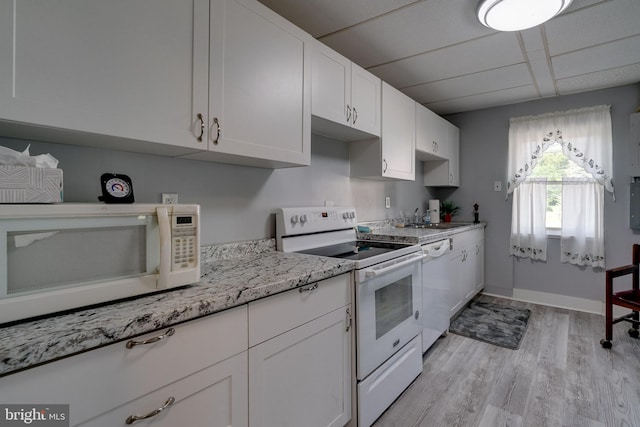 kitchen with light hardwood / wood-style floors, a paneled ceiling, white appliances, white cabinetry, and sink