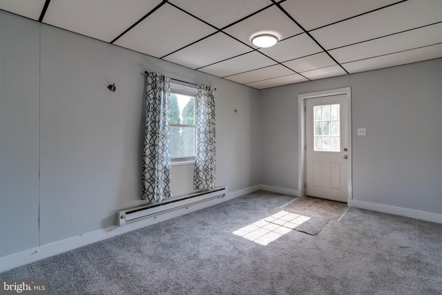 carpeted spare room with a paneled ceiling and baseboard heating