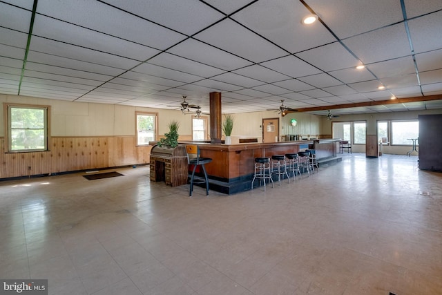 interior space featuring ceiling fan, a paneled ceiling, and plenty of natural light