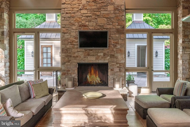 living room with a towering ceiling, a wealth of natural light, and a fireplace