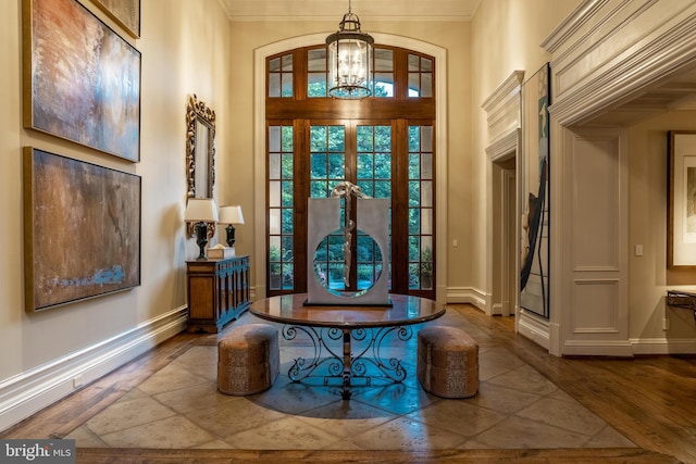 foyer entrance with a notable chandelier, crown molding, french doors, and dark hardwood / wood-style flooring