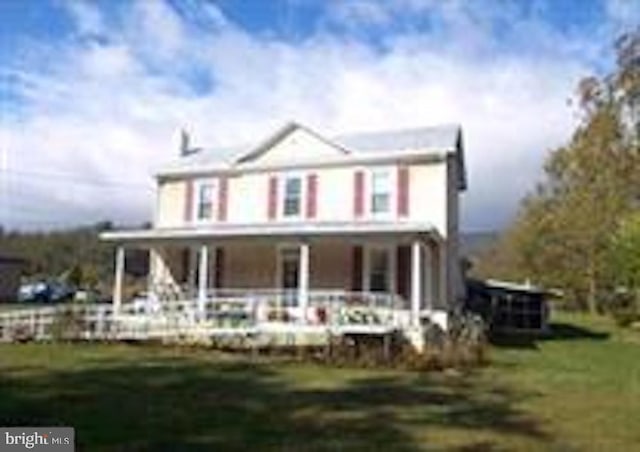 rear view of property featuring a lawn