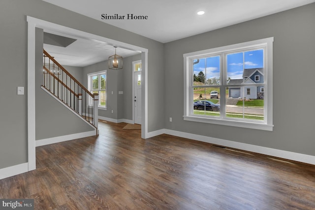 foyer featuring an inviting chandelier and dark hardwood / wood-style floors