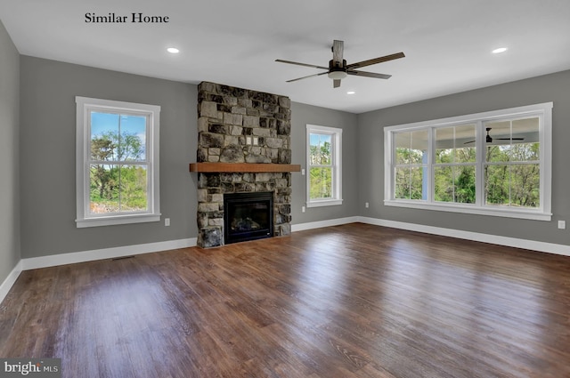 unfurnished living room with ceiling fan, a fireplace, and dark wood-type flooring