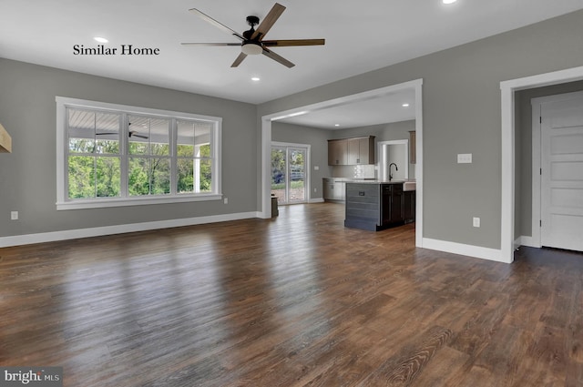 unfurnished living room with ceiling fan, dark wood-type flooring, and sink