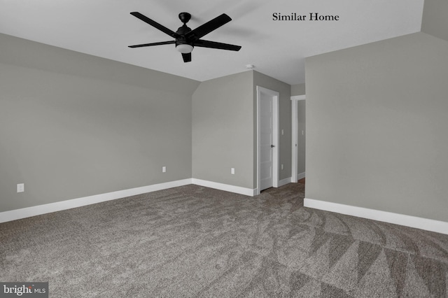 empty room featuring dark carpet, ceiling fan, and vaulted ceiling