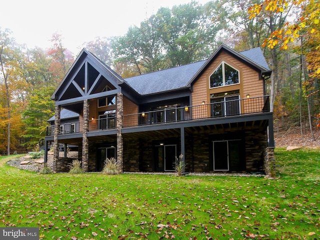 back of house featuring a balcony and a lawn