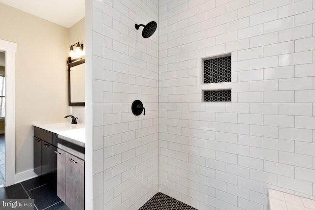 bathroom with tile floors, a tile shower, and oversized vanity