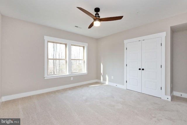 unfurnished bedroom with a closet, light carpet, and ceiling fan