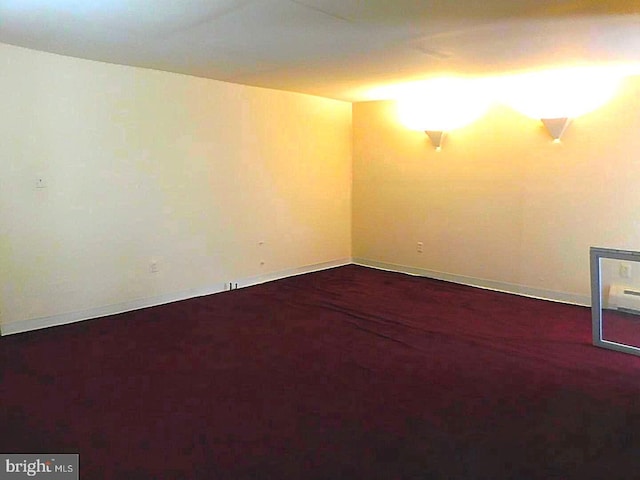 spare room featuring dark colored carpet