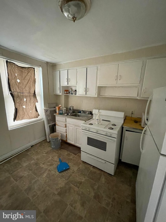 kitchen with dark tile flooring, white appliances, white cabinetry, and sink