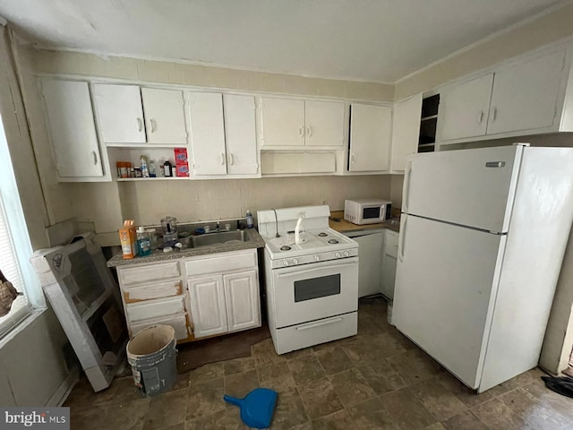 kitchen featuring sink, white appliances, white cabinetry, and dark tile flooring