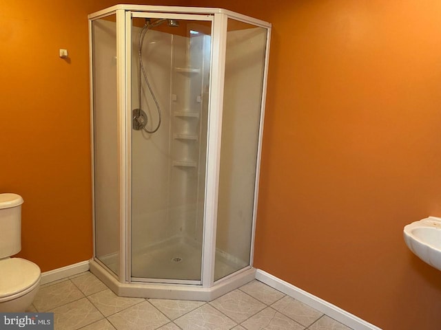 bathroom featuring tile patterned floors, toilet, and an enclosed shower