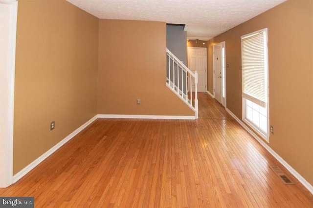 spare room with hardwood / wood-style floors and a textured ceiling