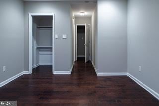 unfurnished bedroom featuring dark wood-type flooring and a closet