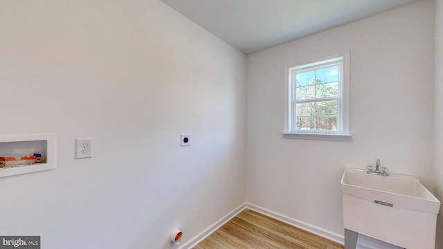 clothes washing area with washer hookup, hookup for an electric dryer, sink, and light wood-type flooring