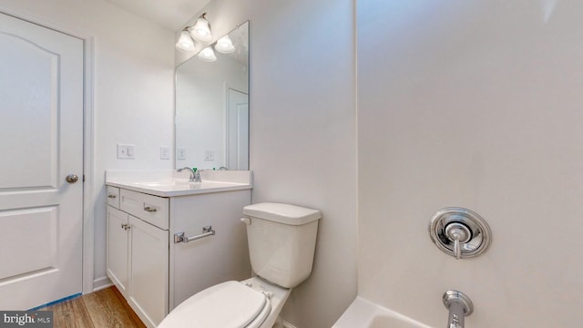 bathroom with hardwood / wood-style flooring, large vanity, and toilet