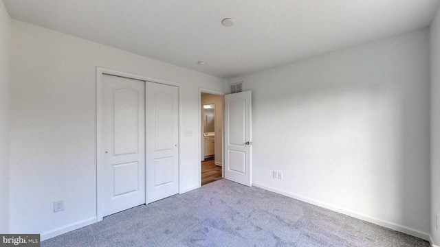 unfurnished bedroom with a closet and carpet floors