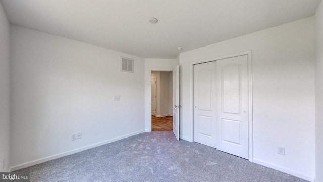 unfurnished bedroom with a closet and dark hardwood / wood-style flooring