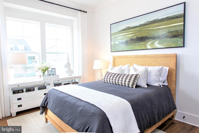 bedroom featuring ornamental molding and hardwood / wood-style flooring