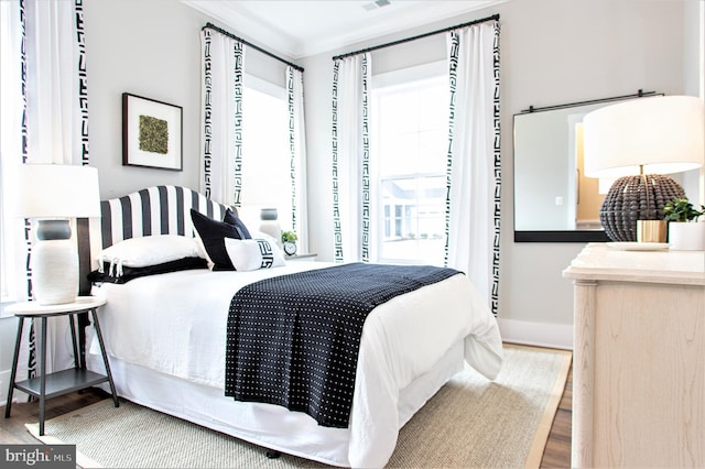 bedroom with multiple windows and light hardwood / wood-style floors