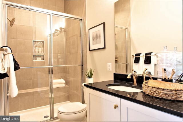 bathroom with oversized vanity, toilet, and a shower with door