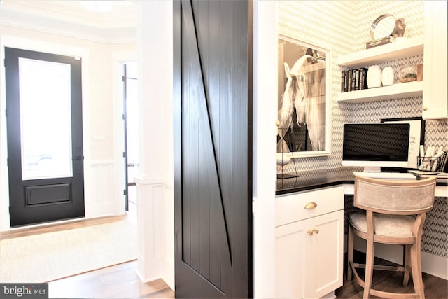 home office featuring wood-type flooring and crown molding