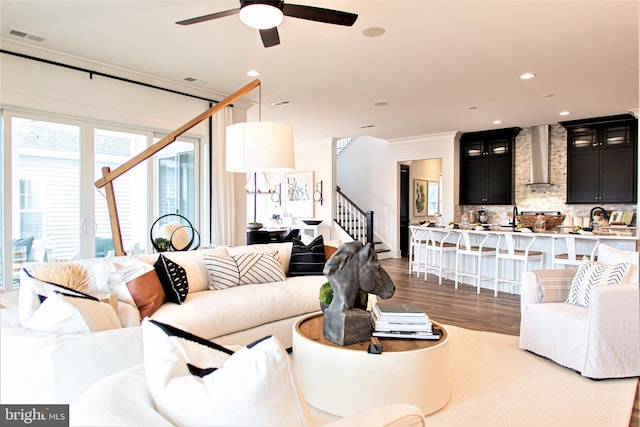 living room with dark hardwood / wood-style floors, ceiling fan, sink, and ornamental molding