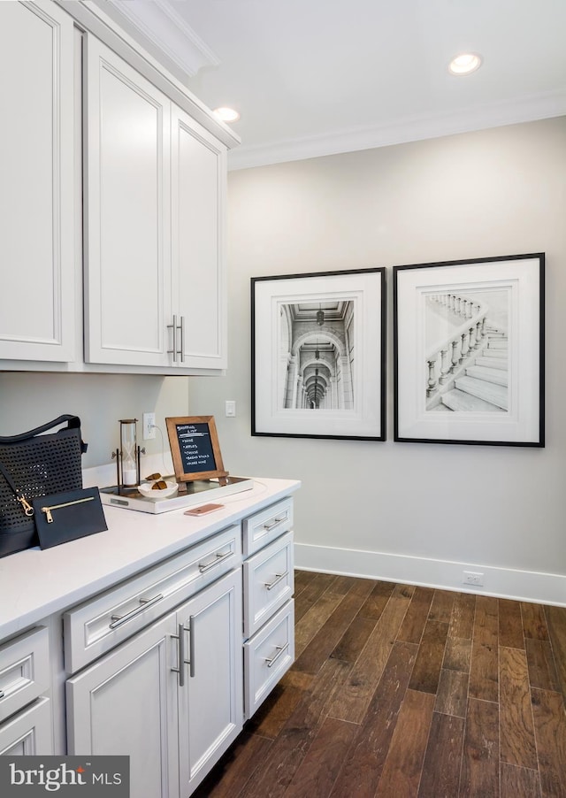 kitchen with dark hardwood / wood-style flooring, white cabinetry, and crown molding