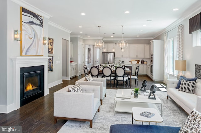 living room with ornamental molding, a chandelier, and wood-type flooring