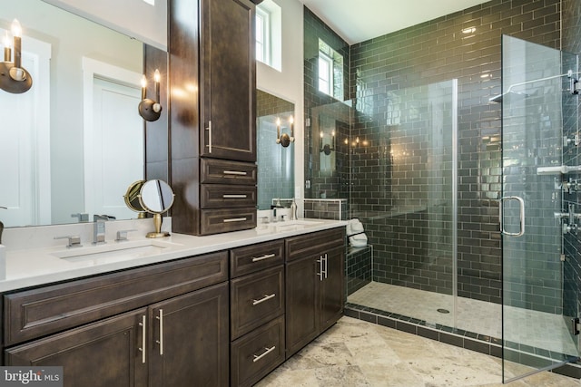 bathroom featuring tile flooring, dual sinks, a shower with door, and vanity with extensive cabinet space