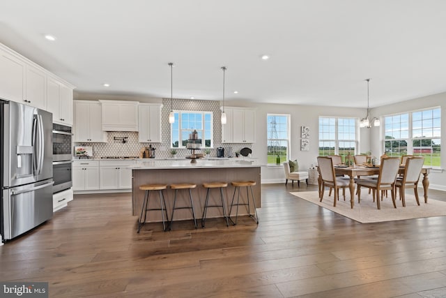 kitchen with white cabinets, a healthy amount of sunlight, pendant lighting, and stainless steel appliances