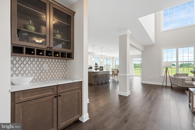 bar with backsplash, dark hardwood / wood-style floors, and a wealth of natural light