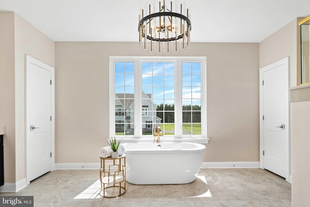 interior space featuring a chandelier, plenty of natural light, tile flooring, and a washtub