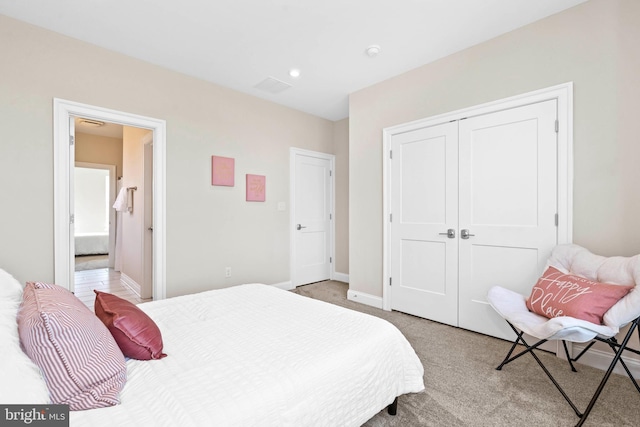 bedroom featuring a closet and light colored carpet