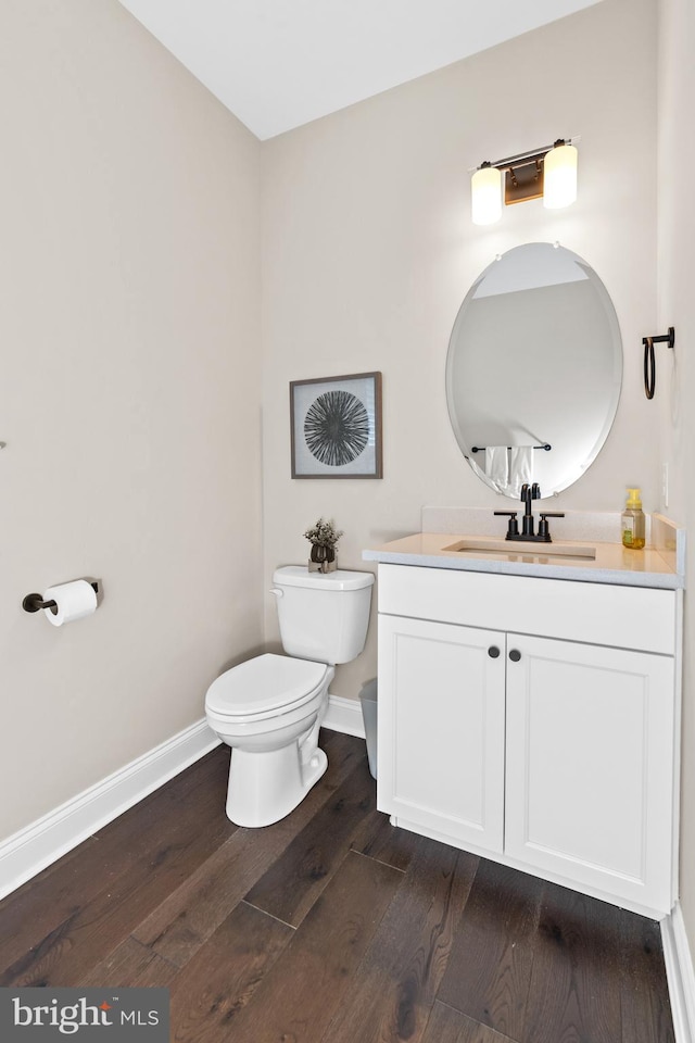 bathroom featuring toilet, vanity, and hardwood / wood-style flooring